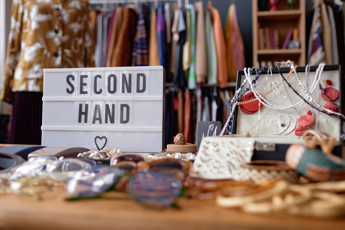 Vintage jewelry displayed in a case beside a second hand sign