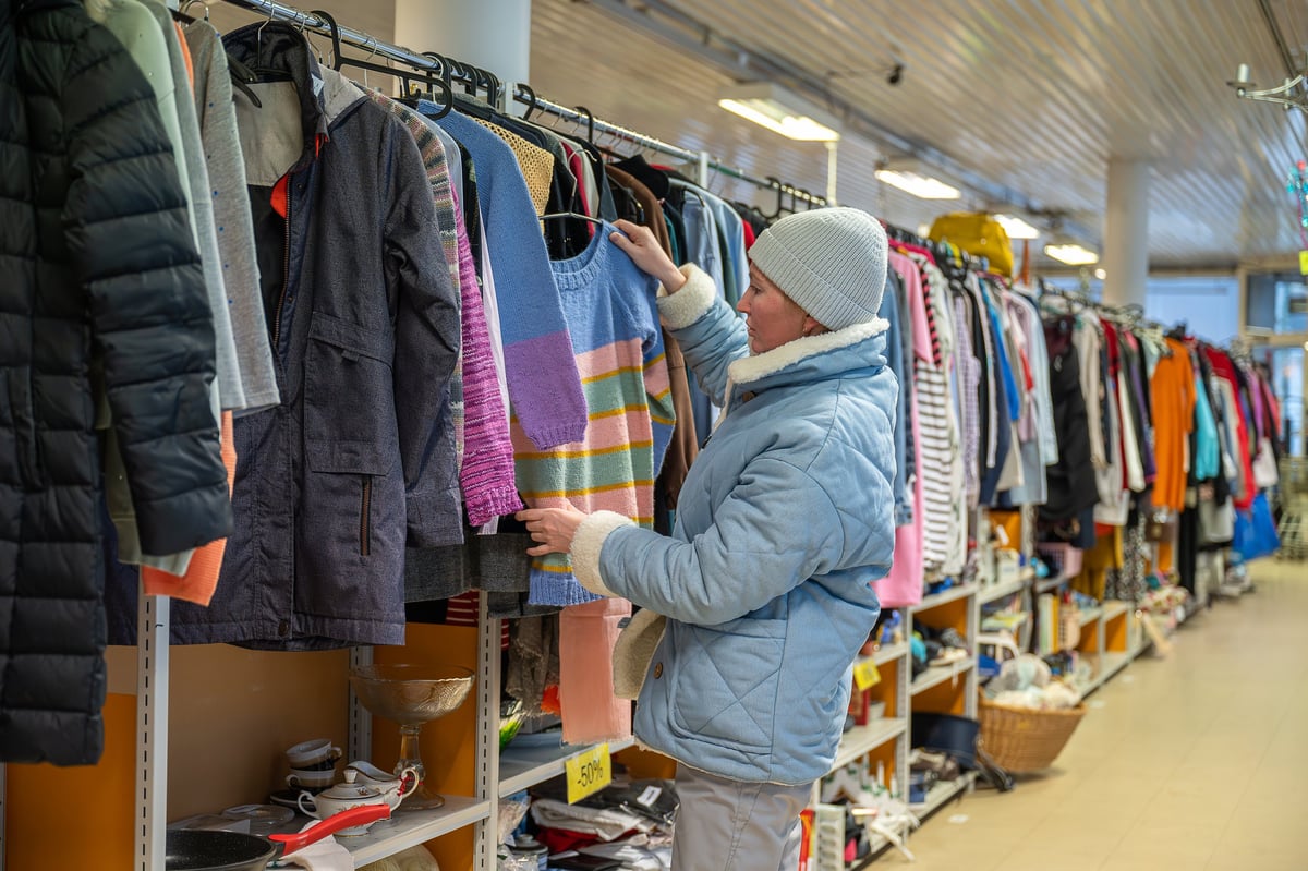 Shopper browsing colorful clothing racks in a community thrift shop